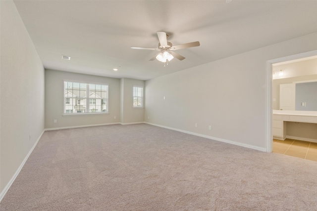 unfurnished room with a ceiling fan, carpet, visible vents, and baseboards