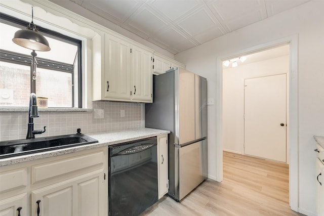 kitchen with freestanding refrigerator, an ornate ceiling, a sink, dishwasher, and tasteful backsplash