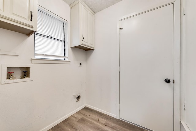 washroom with baseboards, hookup for a washing machine, light wood-style flooring, cabinet space, and electric dryer hookup