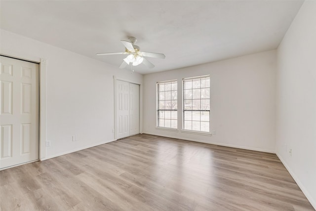 unfurnished room with light wood finished floors, baseboards, and a ceiling fan