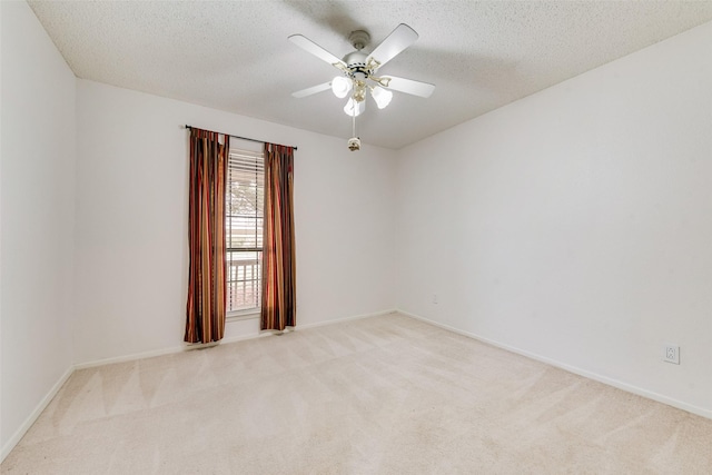 unfurnished room with baseboards, light colored carpet, a textured ceiling, and a ceiling fan