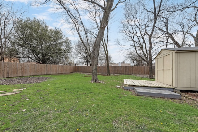 view of yard featuring an outdoor structure, a fenced backyard, and a storage shed