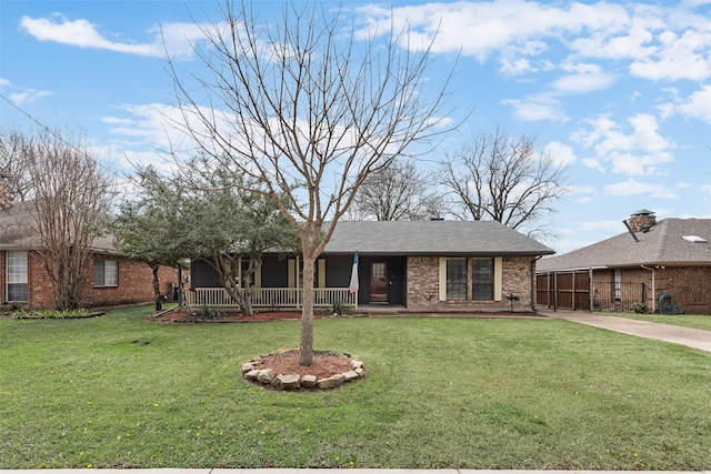 ranch-style home with a porch, brick siding, roof with shingles, and a front lawn