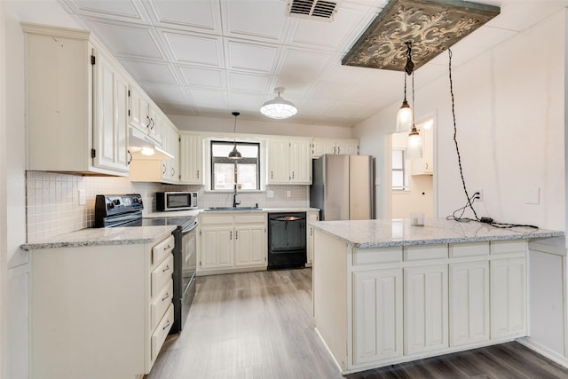 kitchen with visible vents, light wood-type flooring, a peninsula, stainless steel appliances, and a sink