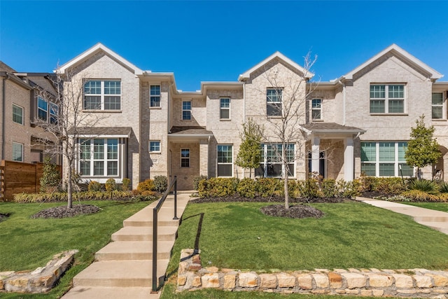 view of front of home featuring a front lawn and brick siding