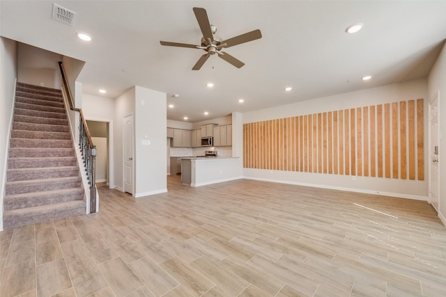 unfurnished living room featuring light wood-type flooring, stairs, visible vents, and recessed lighting