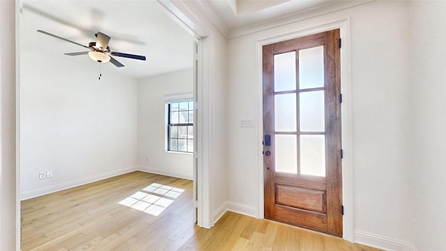 doorway to outside with light wood-style floors, ceiling fan, and baseboards