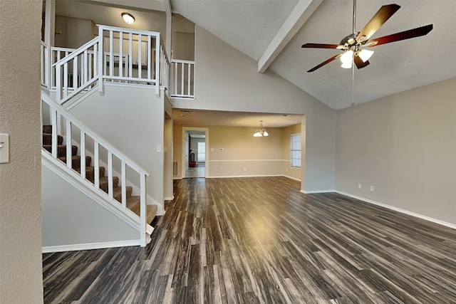 unfurnished living room with baseboards, ceiling fan, stairway, wood finished floors, and beam ceiling