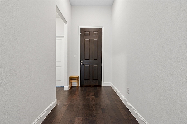 entryway featuring dark wood finished floors and baseboards