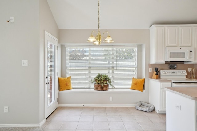 kitchen with white appliances, light tile patterned floors, white cabinets, light countertops, and a notable chandelier