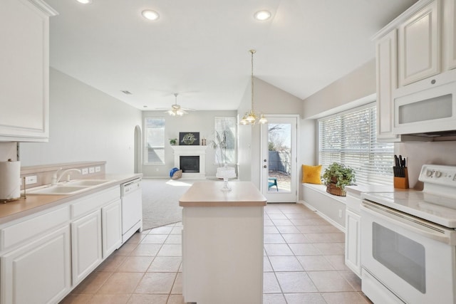 kitchen featuring a kitchen island, white appliances, light countertops, and a sink