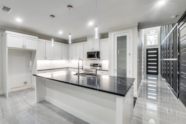 kitchen with stainless steel appliances, a sink, visible vents, white cabinets, and dark countertops