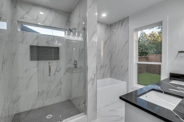 bathroom featuring marble finish floor, a marble finish shower, a tub, and vanity