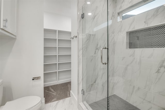 full bathroom with a walk in closet, a marble finish shower, marble finish floor, and toilet