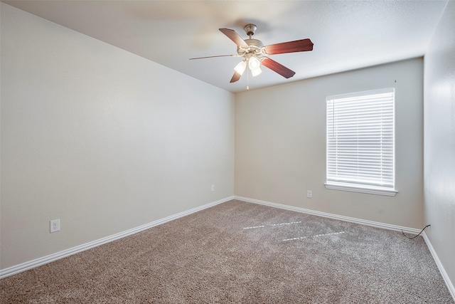 spare room with carpet floors, baseboards, and a ceiling fan