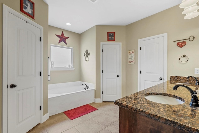 bathroom featuring double vanity, a garden tub, a sink, and tile patterned floors