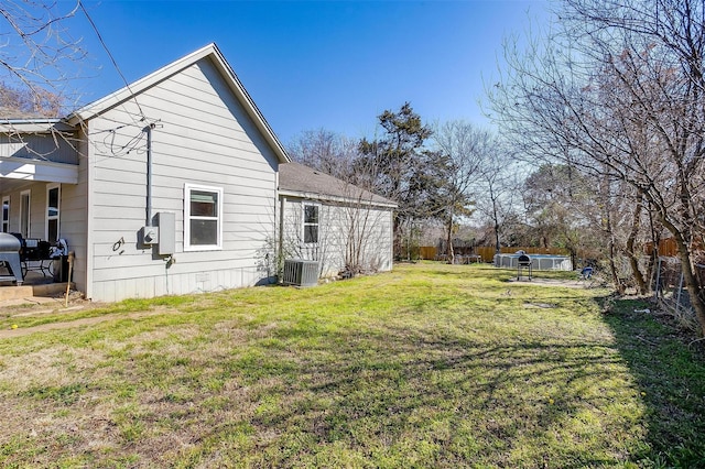 back of property featuring central air condition unit, a yard, and fence