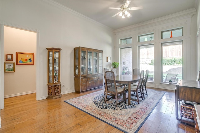 dining area with light wood finished floors, baseboards, ornamental molding, and a ceiling fan