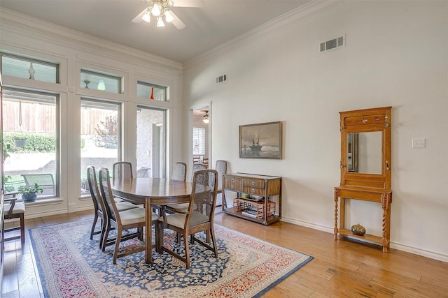 dining room with visible vents, ceiling fan, crown molding, a healthy amount of sunlight, and light wood-style floors