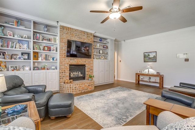 living room with baseboards, a ceiling fan, wood finished floors, crown molding, and a fireplace