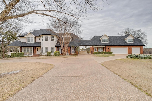 view of front of home featuring covered porch, concrete driveway, and brick siding