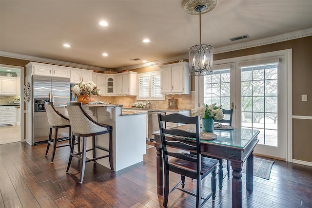 kitchen featuring visible vents, appliances with stainless steel finishes, white cabinets, and dark wood-type flooring