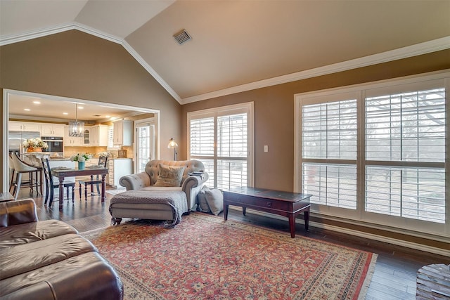 living area with dark wood-type flooring, lofted ceiling, visible vents, and crown molding