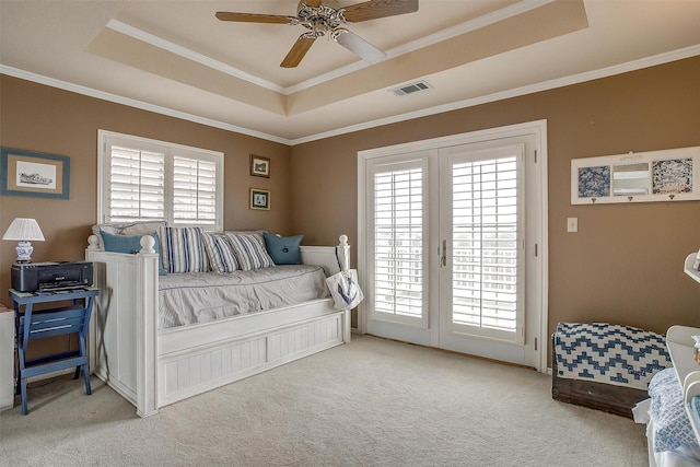 bedroom featuring access to outside, multiple windows, a raised ceiling, and visible vents