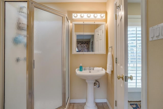 full bathroom with a healthy amount of sunlight, a shower stall, baseboards, and tile patterned floors