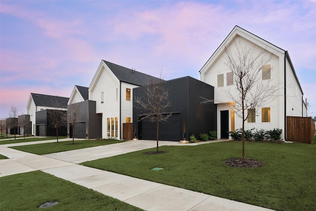 view of front of home featuring fence, a front yard, stucco siding, driveway, and an attached garage