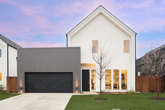 view of front of property featuring stucco siding, driveway, a front lawn, fence, and an attached garage