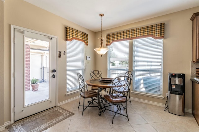 dining area featuring light tile patterned floors and baseboards