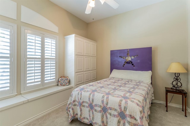 bedroom with a ceiling fan, a closet, light carpet, and baseboards