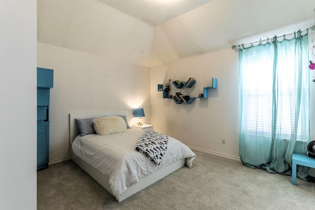 carpeted bedroom with lofted ceiling and baseboards