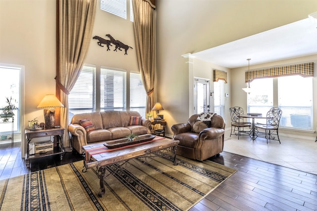 living room with a high ceiling, wood finished floors, and baseboards