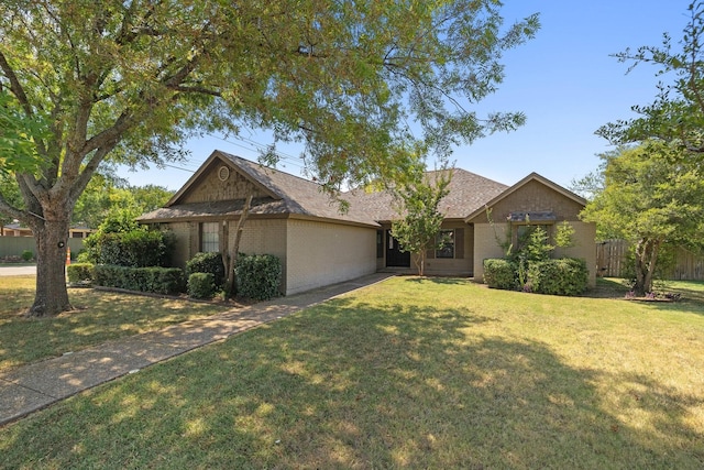 single story home featuring brick siding, a front yard, and fence