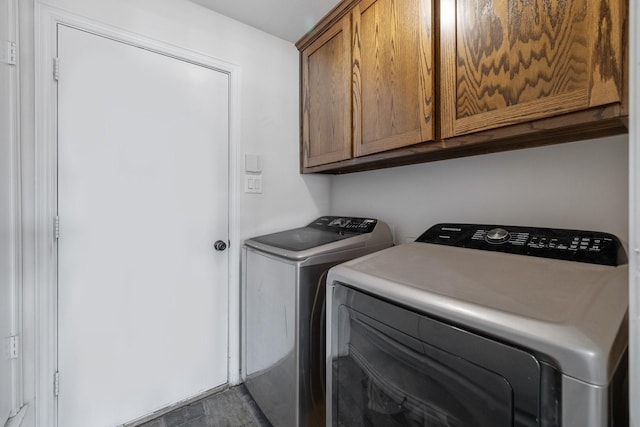 laundry room with washer and dryer, cabinet space, and wood finished floors