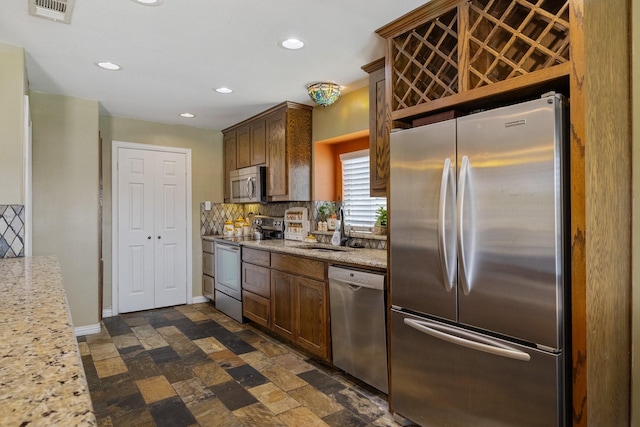 kitchen featuring recessed lighting, visible vents, decorative backsplash, appliances with stainless steel finishes, and a sink