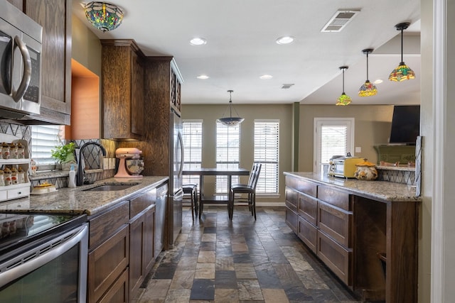 kitchen featuring recessed lighting, a sink, visible vents, appliances with stainless steel finishes, and stone tile flooring