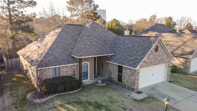 view of front of house featuring concrete driveway, roof with shingles, an attached garage, a front lawn, and brick siding