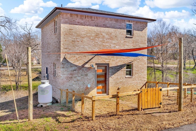 exterior space featuring brick siding and fence