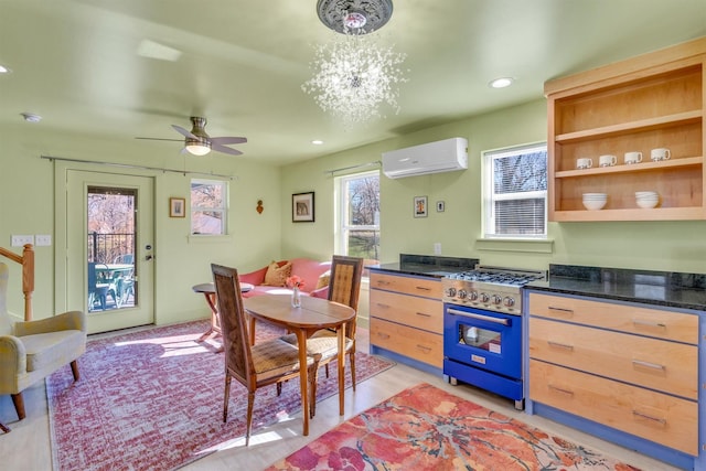 kitchen featuring recessed lighting, ceiling fan with notable chandelier, a wall mounted AC, and stainless steel stove