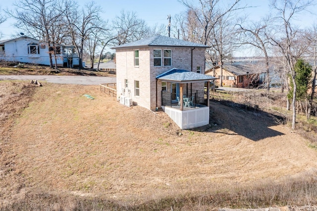 rear view of property featuring a shingled roof