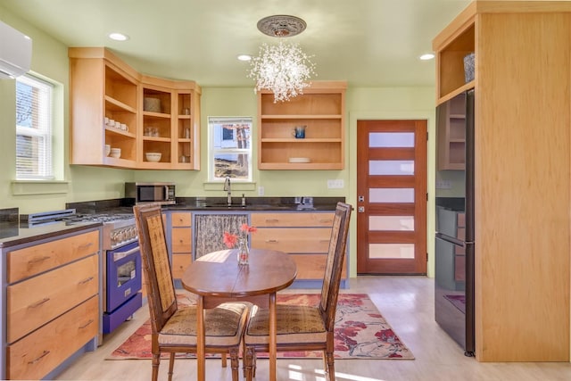 kitchen with a notable chandelier, a sink, open shelves, dark countertops, and appliances with stainless steel finishes