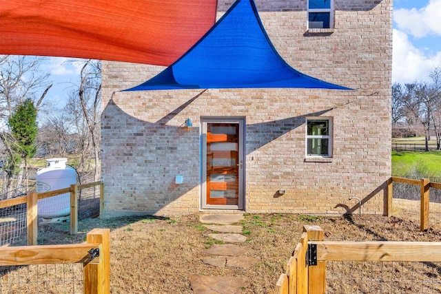 exterior space featuring fence and brick siding