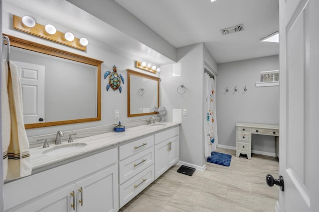 bathroom with visible vents, a sink, baseboards, and double vanity