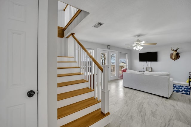 stairs with french doors, visible vents, ceiling fan, and baseboards