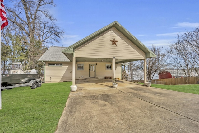 view of front of home featuring driveway, fence, a carport, and a front yard