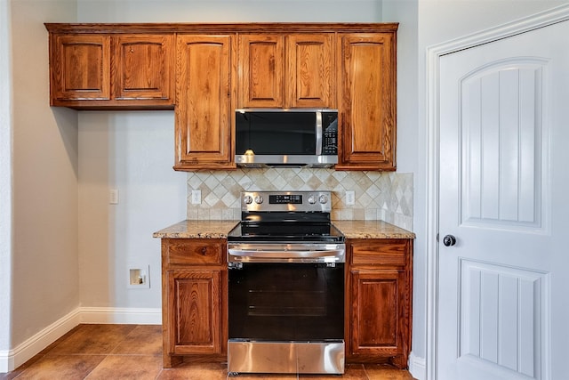 kitchen with baseboards, appliances with stainless steel finishes, light stone countertops, and decorative backsplash