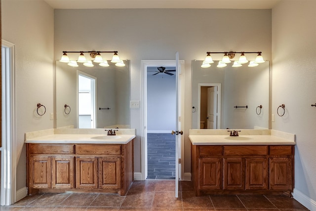 bathroom with two vanities, a sink, and baseboards